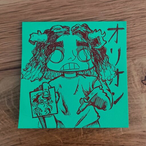 Drawing on a green post-it with red ink of a person pointing a pencil in his left hand and a post-it in his right hand. The character has big, round empty eyes and is grining. He has two horns, one of which is broken. He looks straight at the viewer, perhaps proud of showing his work. 
Behind him japanese character reads as オリオン (Orion)