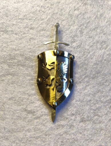 A shield and sword pendant. It is made of two metal plates, the first one is made of aluminium, and the top one is brass. the brass plate shows a pattern of a medieval griffon, with inverted "colors" on each half, and is riveted to the aluminium plate to give a 3d effect.